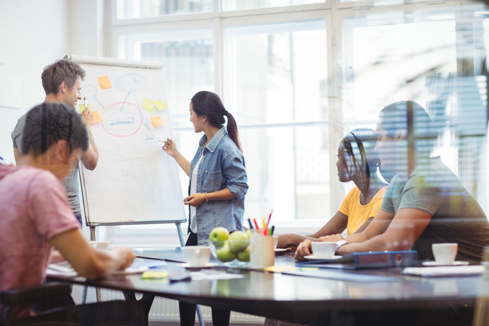 Business executives discussing with their colleagues on whiteboard